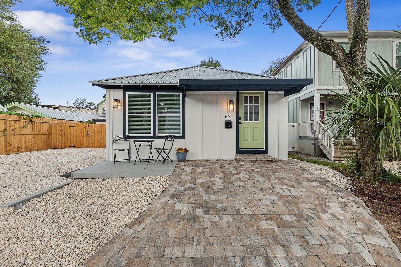 63 Oneida St exterior - restored 1925 cottage with green door and paver drive